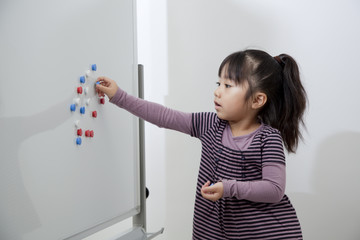 ホワイトボードで遊ぶ女の子