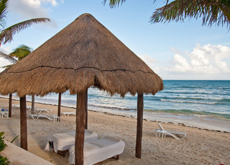 Fototapeta premium Massage Tables Under Thatched Hut on Beach