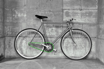 A fixed-gear bicycle in black and white with a green chain