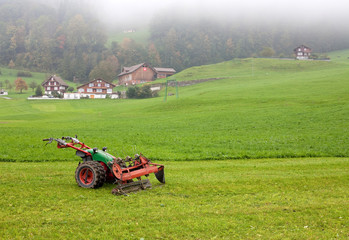 Fototapeta premium tractor standing next to the mowed grass