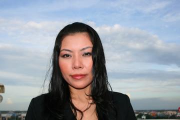 Asian business woman under a cloudy sky.