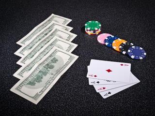 Casino chips, for ace from cards and US dollars on dark surface
