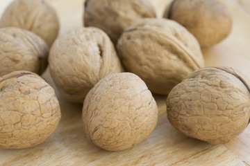 Whole walnuts on wooden background. Closeup.