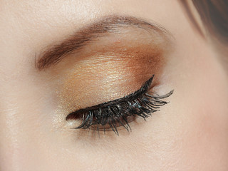 Beautiful macro shot of eye with long lashes and make-up in brow