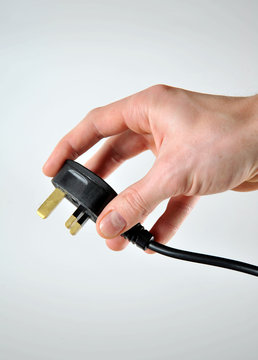 Hand holding UK 3 pin plug