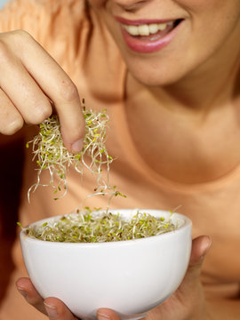 Young Woman Eating Alfalfa Sprouts. Model Released