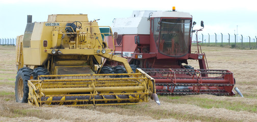 old and new combine harvesters in field