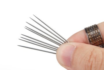 Thread,needle and thimble on white background