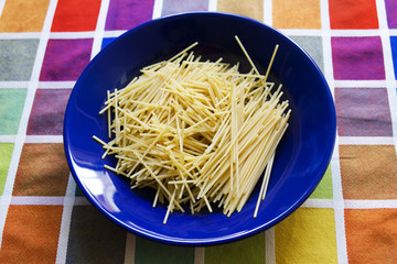 Pasta cruda nel piatto blu