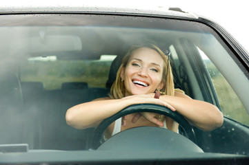 happy cheerful attractive woman in the new car
