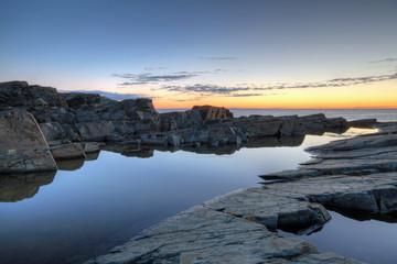 Rocks and water along the Newfoundland coastline at sunrise.