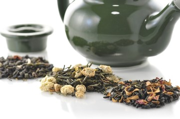 teapot and variety of loose tea with fruits and flowers
