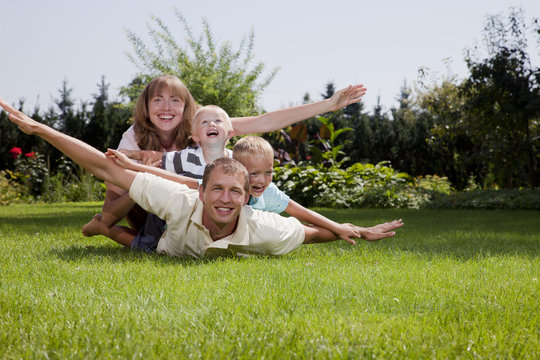 Family playing airplane outdoors