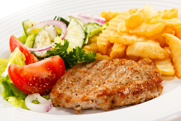 Grilled meat, French fries and vegetables