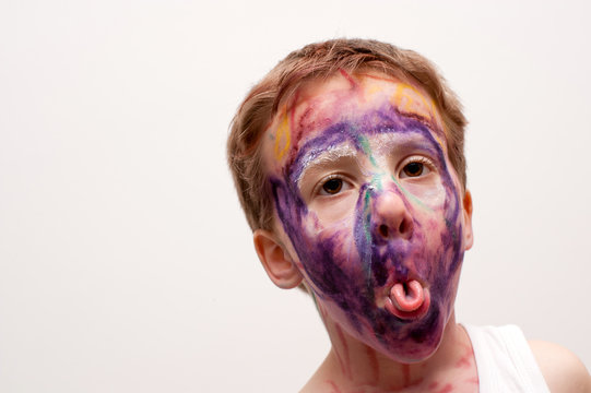 bambino con viso mascherato e linguaccia