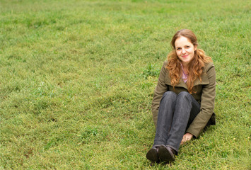 Redhead woman sitting on the grass