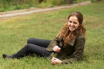Fototapeta premium Redhead woman lie on the grass