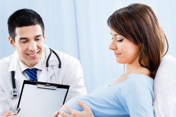 Doctor and pregnant woman with prescription at office