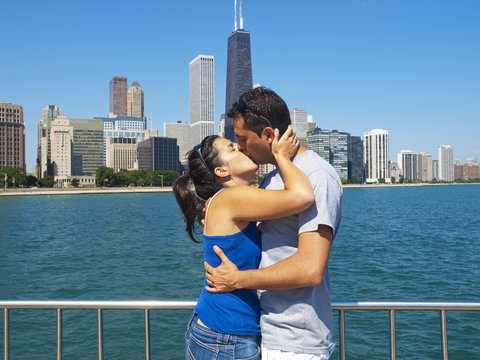 Young couple kissing in front of the Chicago Skyline
