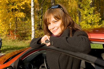 Young women with key near the her red car