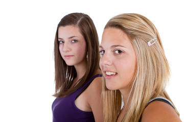 Two young girl friends smiling - isolated over white background.