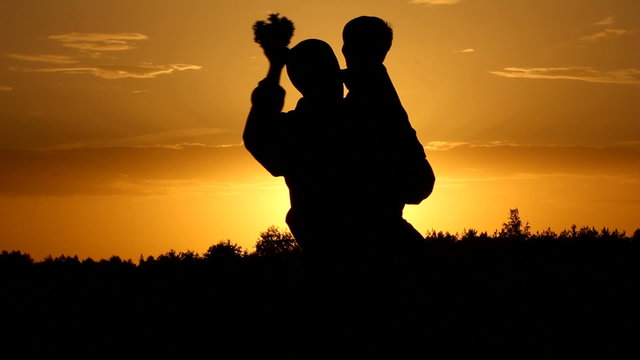 Happy family. A sunset. Silhouettes.