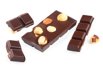 Pieces of chocolate bar with nuts on white background