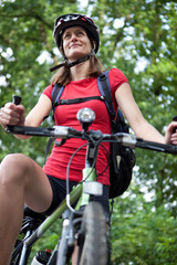 Fototapeta premium pretty young female biker outddors on her mountain bike (shallow