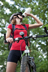 Fototapeta premium pretty young female biker outddors on her mountain bike (shallow