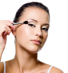 woman applying eyeshadow with brush