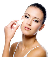 woman applying foundation on face