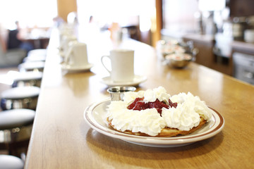 Strawberry waffle with lots of whip cream and syrup