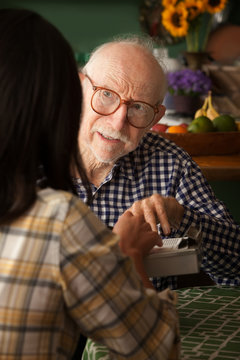 Elderly man in home with care provider or survey taker
