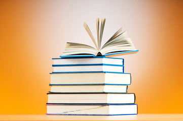 Stack of text books against gradient background