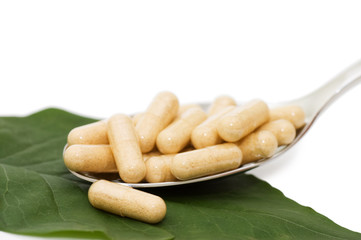 Pills in a spoon isolated on white background