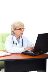 Busy senior woman doctor in office