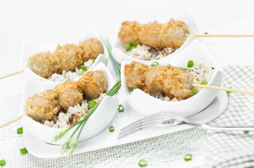 fried meatballs with rice in a white bowl