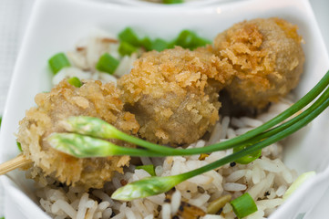 fried meatballs with rice in a white bowl