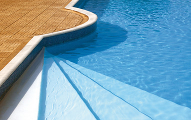 Obraz na płótnie Canvas Steps to the swimming pool. Rippled water under sunlight