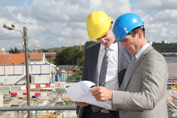 Architects checking plan on construction site