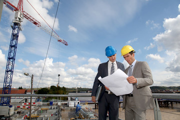 Architects checking plan on construction site