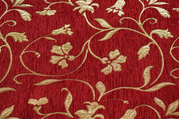 Fototapeta na wymiar Red velvet fabric with golden flower motif