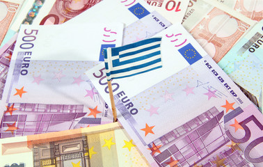 Euro banknotes and greek flag