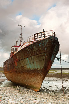 Dead fishing boat on the beach
