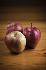 Three apples on wooden table