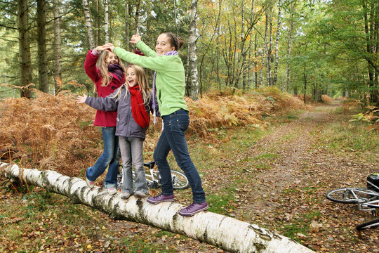 Trois jeunes filles jouant en forêt