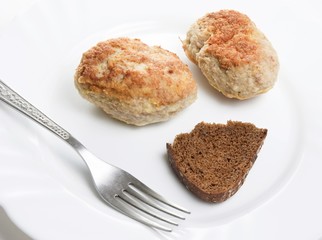 rusishe meatloaf (chop) with bread and fork on plate.