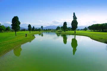 Fototapeta na wymiar Golf course green grass field lake reflection