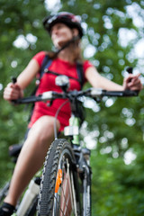 Obraz premium pretty young female biker outddors on her mountain bike (shallow