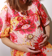 Smiling pregnant woman holding her belly